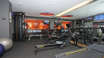 A gym with exercise equipment, a treadmill, and a wall with motivational words.