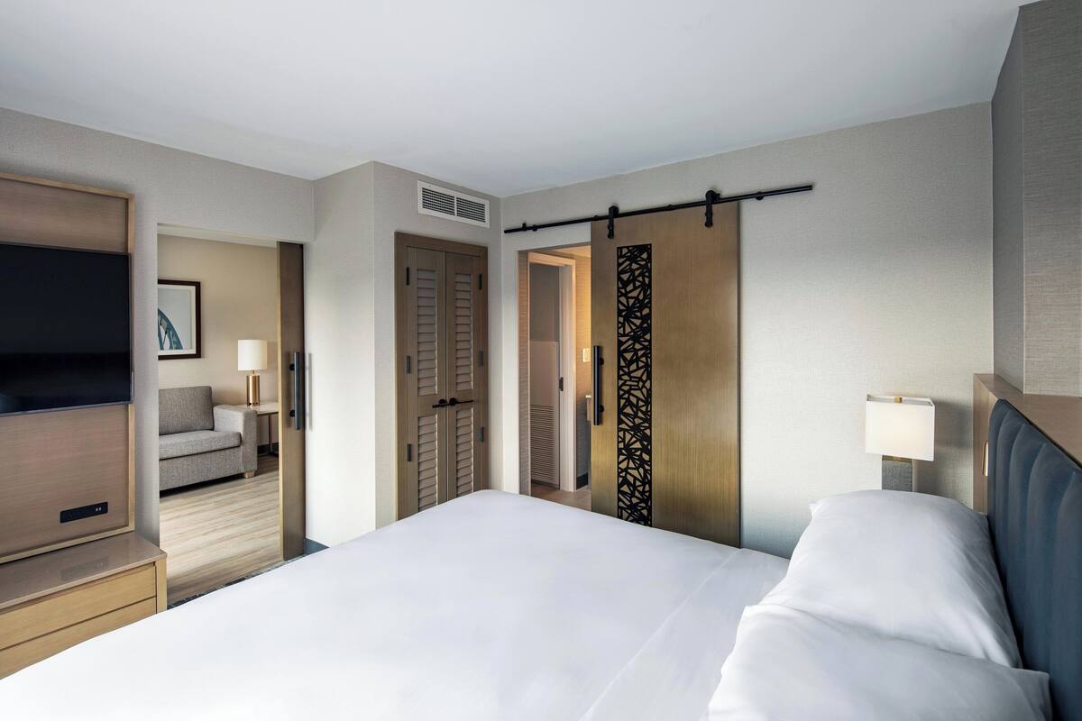 A hotel room with a bed, a TV, a sofa, and a desk.