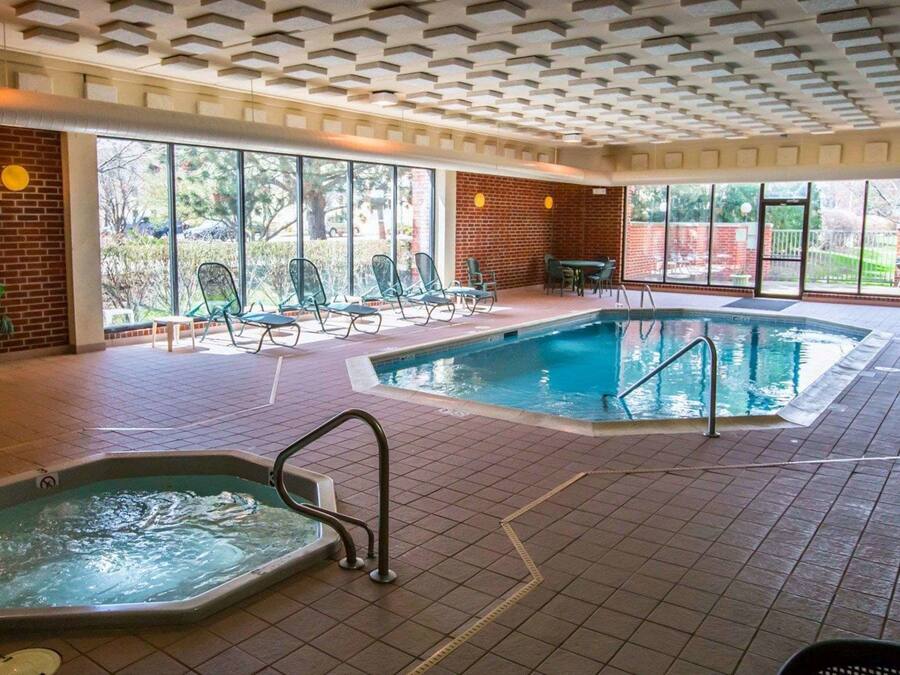 Een binnenzwembad, ligstoelen bij het zwembad