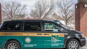 Una furgoneta verde y amarilla estacionada frente a un edificio de ladrillo.