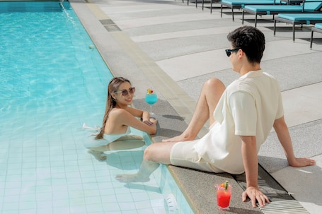 Outdoor pool, pool umbrellas, sun loungers. Holiday Inn Bangkok Silom by IHG