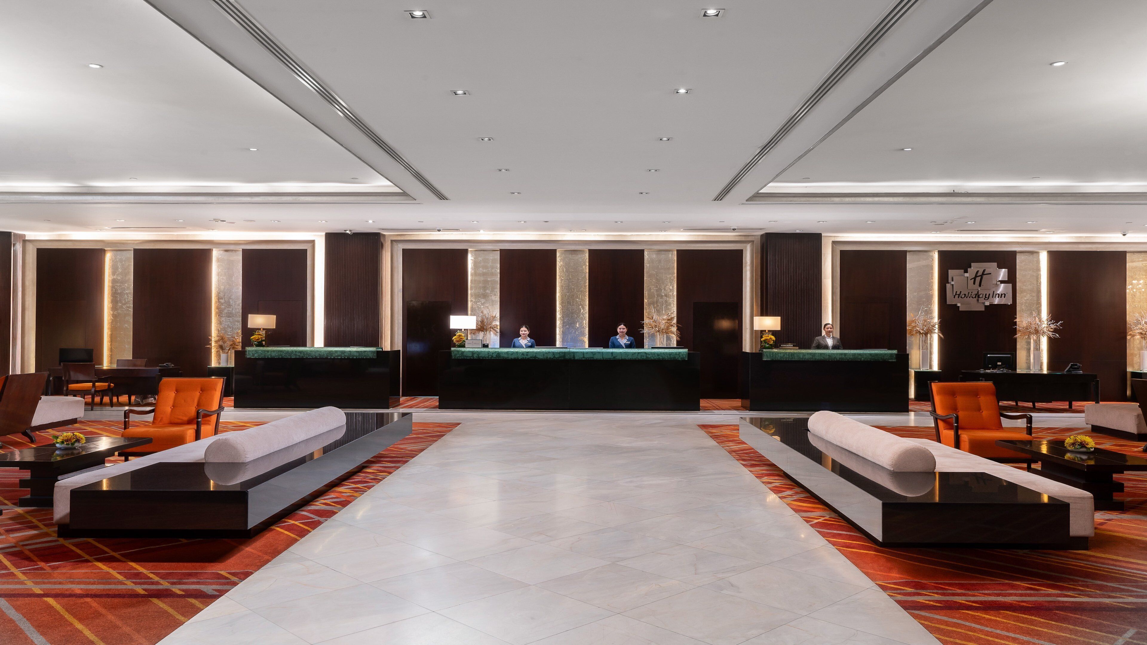A spacious lobby with a reception desk, seating areas, and a modern design.