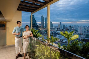 A man and woman standing on a balcony with a cityscape view. - Holiday Inn Bangkok Silom by IHG (Bangkok)