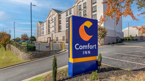 Een Comfort Inn hotel met een opvallend bord, een parkeerplaats en een gebouw met veel ramen.
