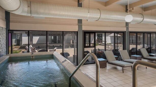 Una piscina interna con sedie a sdraio e vista sull'esterno.