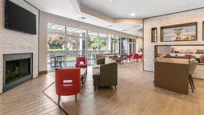 Un moderno vestíbulo de hotel con chimenea, zona de estar y bar.