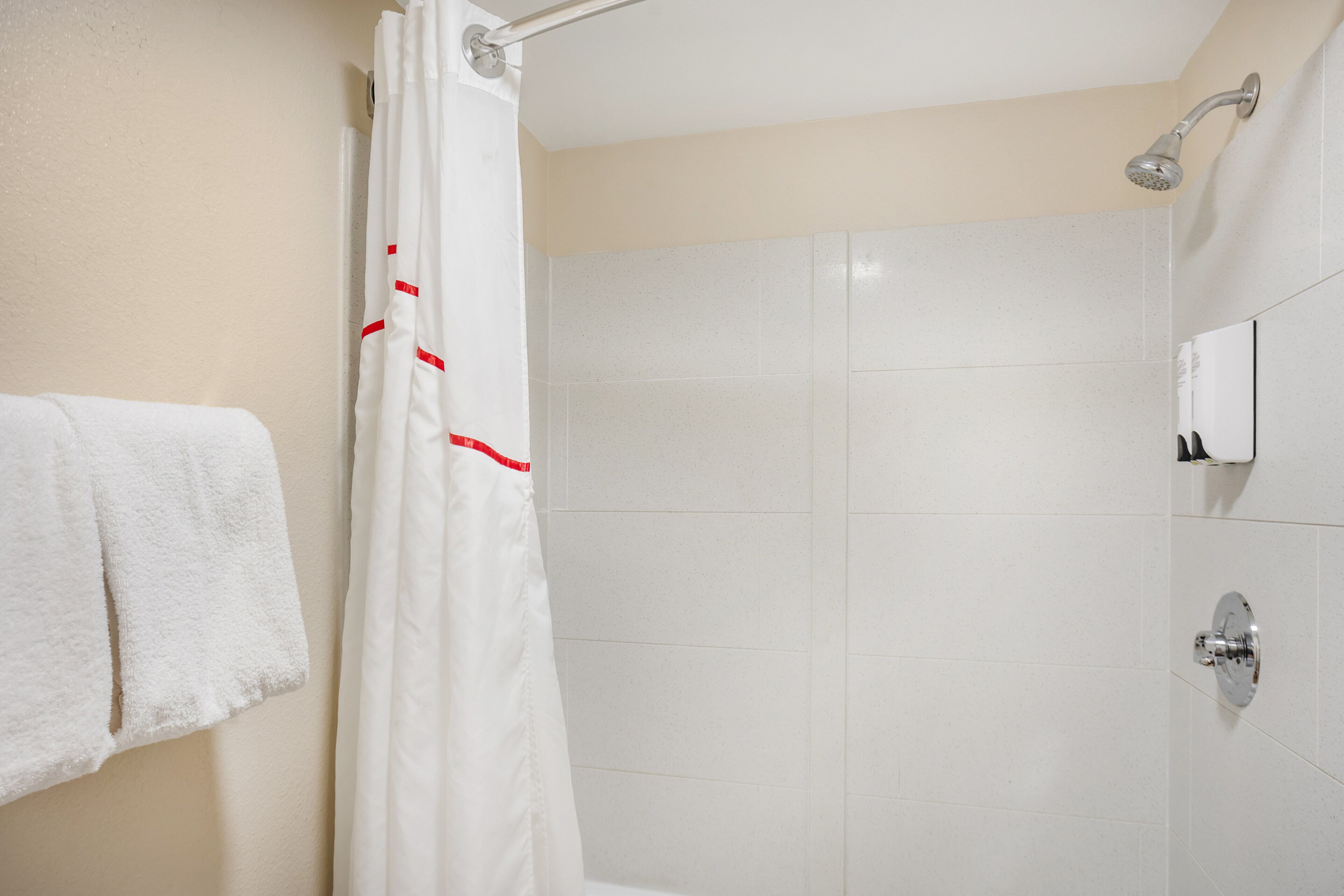 A bathroom with a shower, a towel rack, and a toilet.