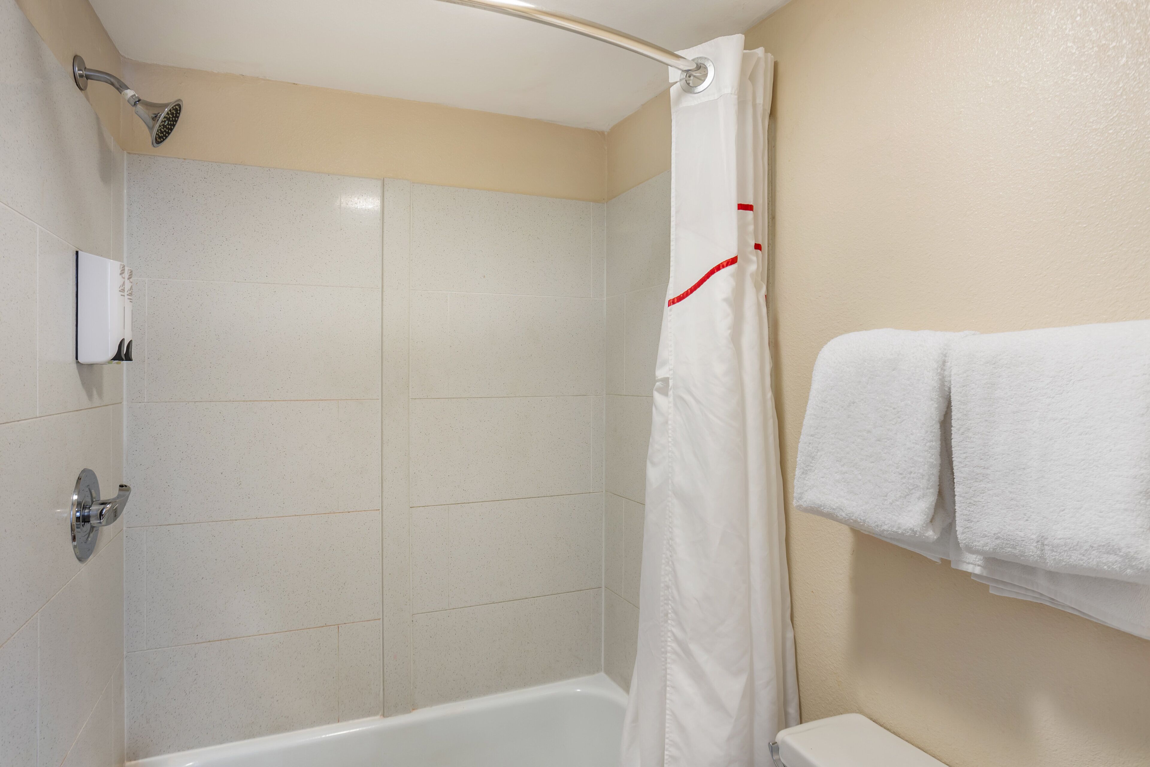 Ein Badezimmer mit Dusche, Toilette und Handtuchhalter.