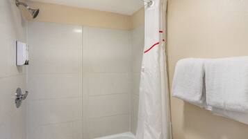 Ein Badezimmer mit Dusche, Toilette und Handtuchhalter.
