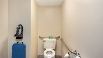 A small, single-occupancy bathroom with a toilet, a hand dryer, and a towel rack.
