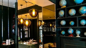 A modern interior with a reception desk, globe collection, and unique lighting fixtures. - Hôtel de Neuville (Paris)
