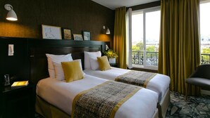 A hotel room with two beds, a nightstand, a chair, a window with curtains, and a balcony view. - Hôtel de Neuville (Paris)