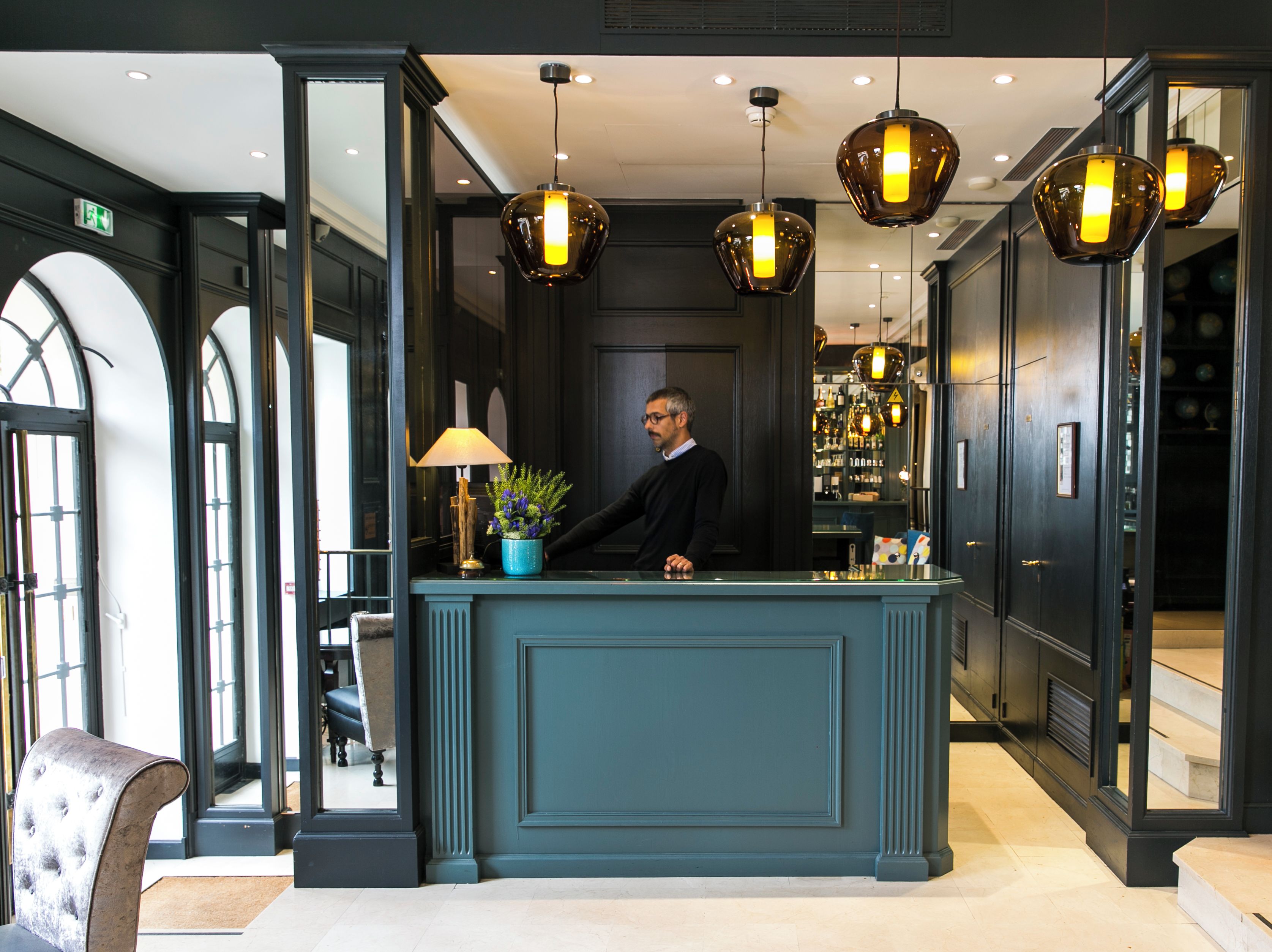 A reception area with a counter, a lamp, and a plant.