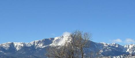 A mountain range with snow-capped peaks under a clear blue sky.