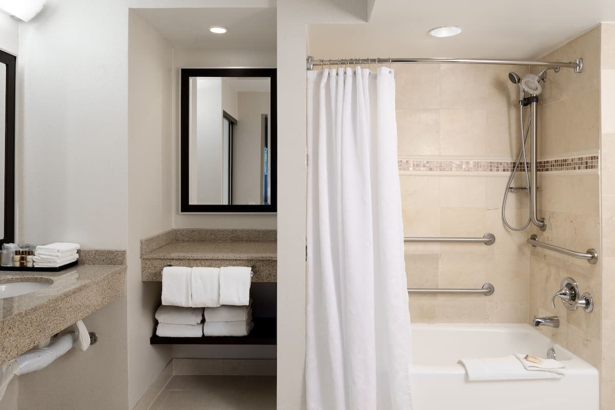 suite, 1 king bed with sofa bed (mobility/hearing accessible, tub) | bathroom | combined shower/bathtub, designer toiletries, hair dryer, towels