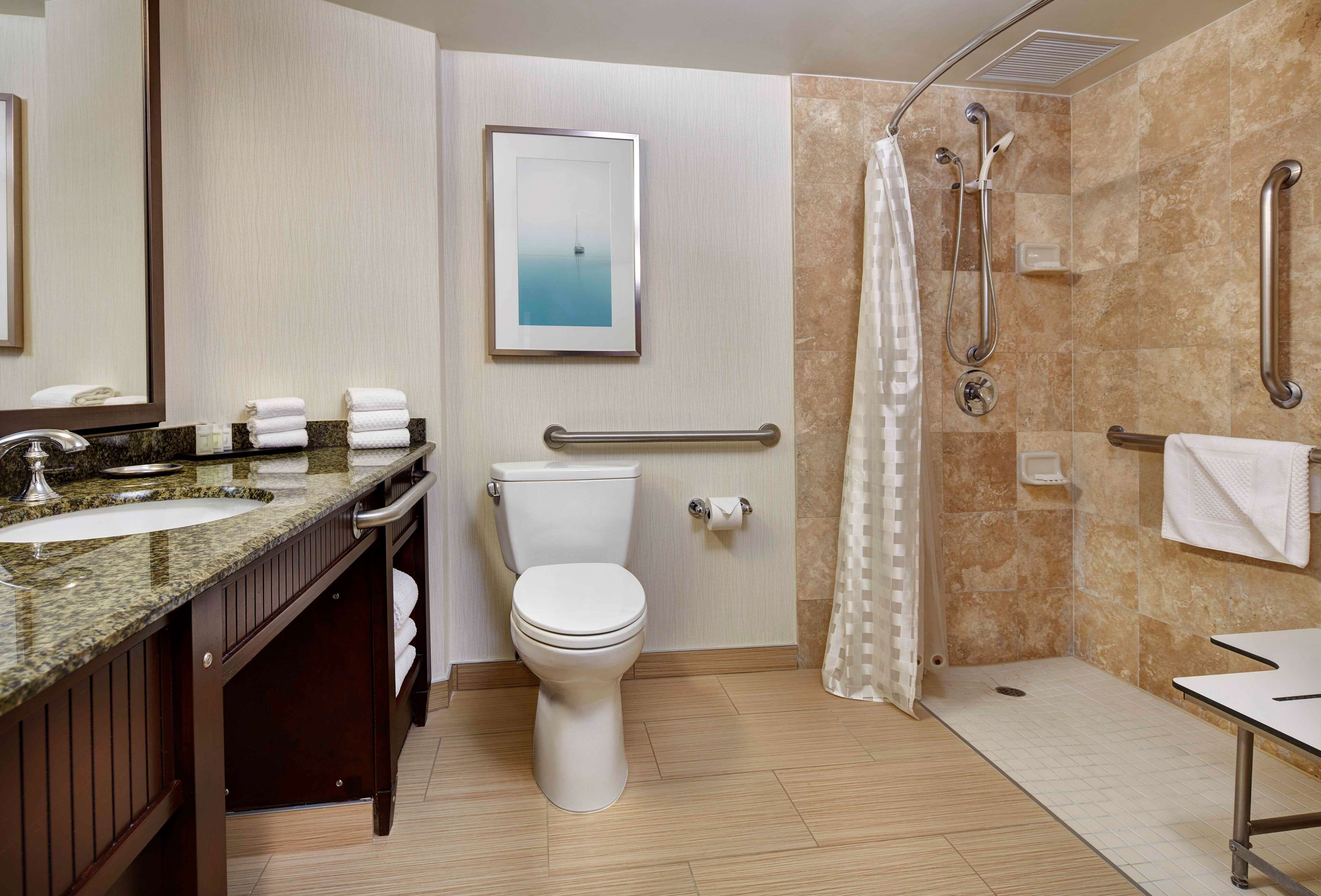 Een moderne badkamer met toilet, wastafel en douche.