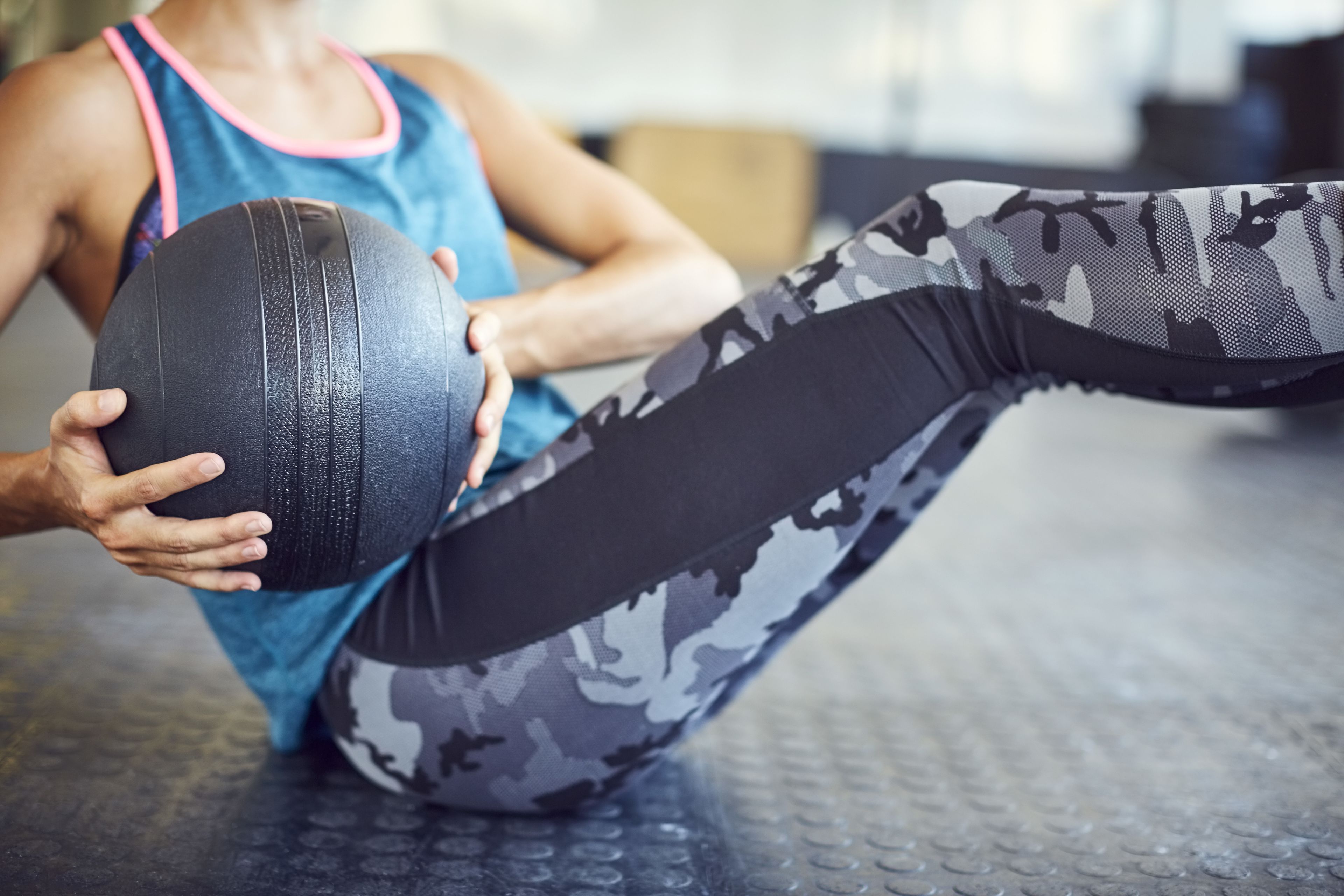 A person performing an exercise with a medicine ball.