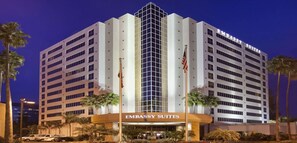 Een meerhoog gebouw met het bord 'EMBASSY SUITES' bovenop.