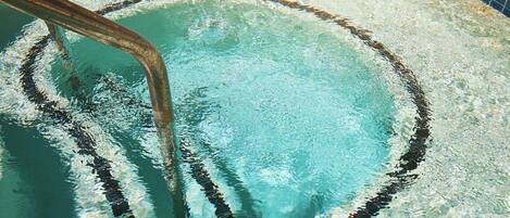 Ein Swimmingpool mit sichtbarem Wasserfiltersystem und einer Fliesenverkleidung.