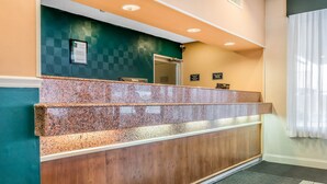 A reception desk with a checkered wall, a wooden panel, and a sign that says "DELL". - Baymont by Wyndham Milesburg (Howard)