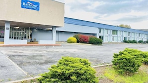 A Baymont by Wyndham hotel with a parking lot and well-maintained landscaping. - Baymont by Wyndham Milesburg (Howard)
