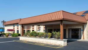 A hotel with a brown roof, a covered entrance, and a sign for a restaurant and lounge. - Days Inn by Wyndham Hillsborough (Hillsborough)