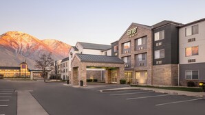 A hotel with a stone facade, multiple stories, and a prominent entrance with a covered area.