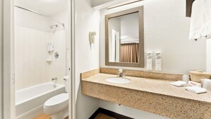 Une salle de bain avec une baignoire, des toilettes, un lavabo et un miroir.