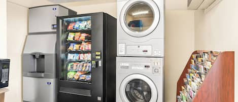A vending machine with snacks, a coffee machine, and a stacked washer-dryer unit.