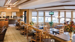 Ein Restaurant mit Holzkubaturen, einer Bar und großen Fenstern.