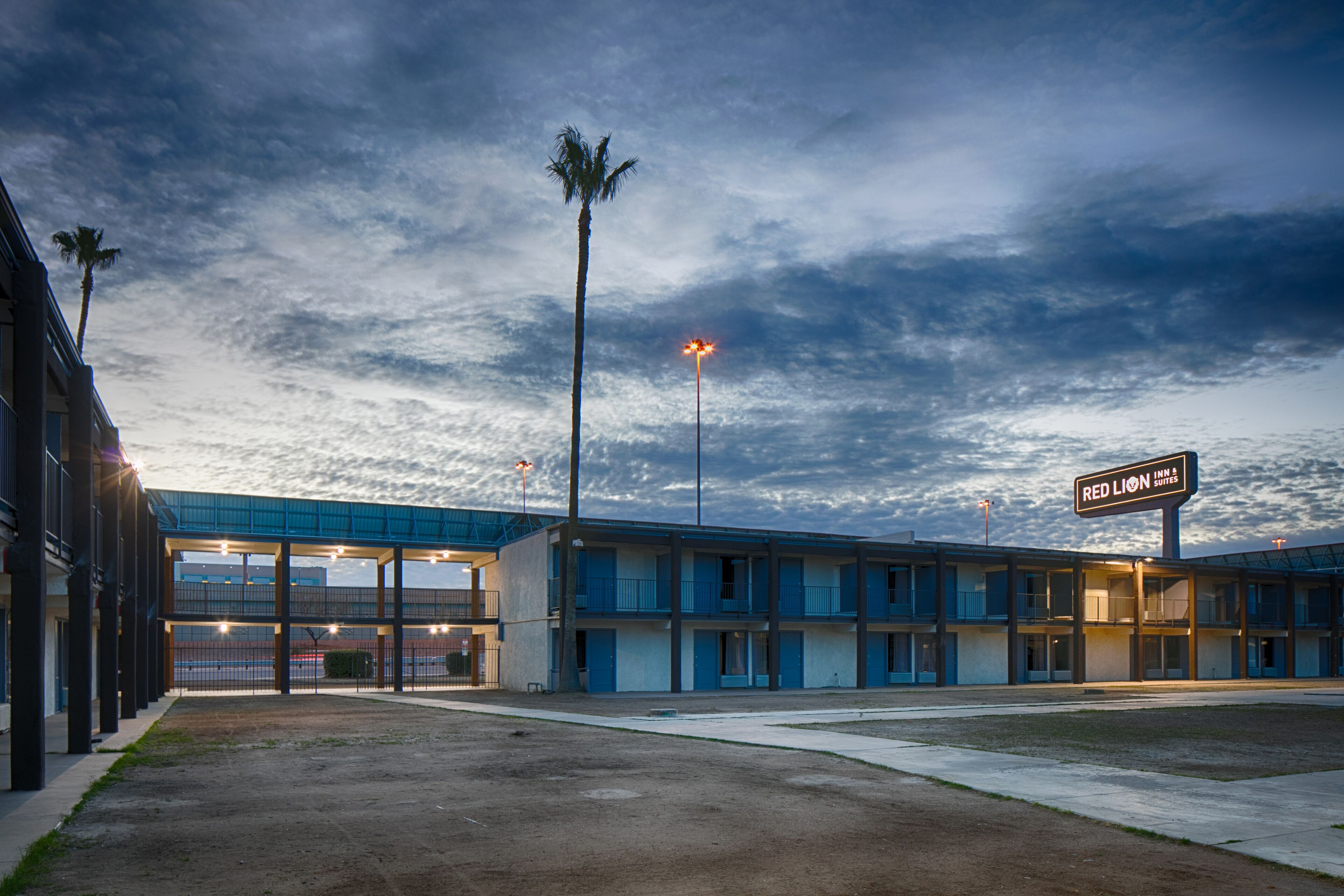 A motel with a sign reading "Red Lion Inn & Suites" under a cloudy sky.
