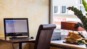 Un bureau avec un ordinateur portable, une chaise, une lampe et une imprimante.
