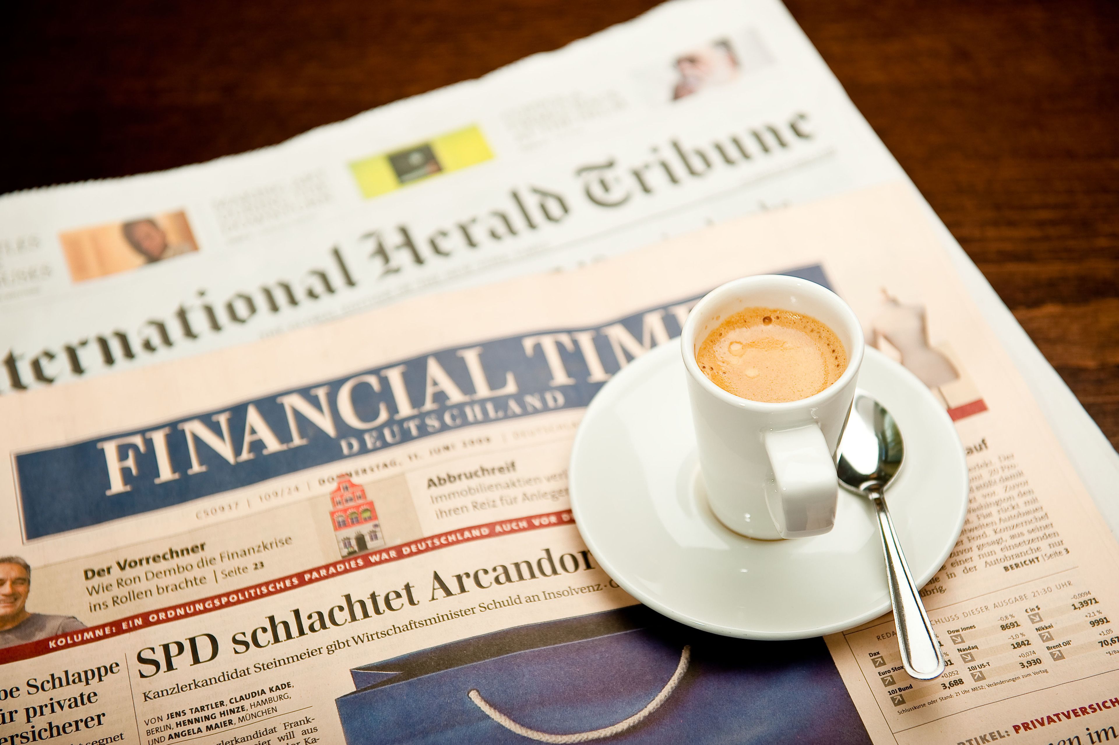 Un periódico con una taza de café encima.