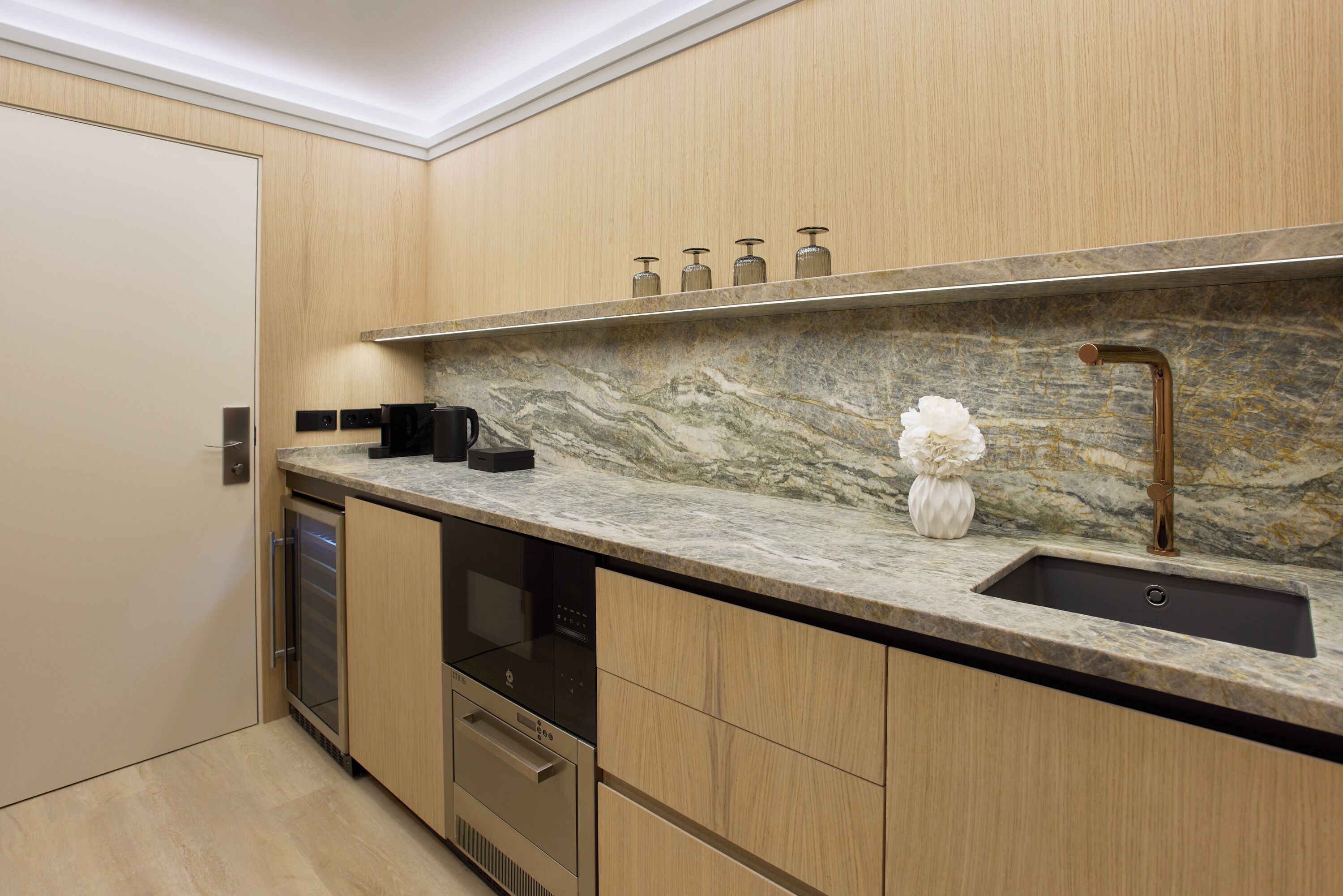 A modern kitchen with a marble countertop, stainless steel appliances, and a built-in dishwasher.