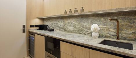 A modern kitchen with a marble countertop, stainless steel appliances, and a built-in dishwasher.