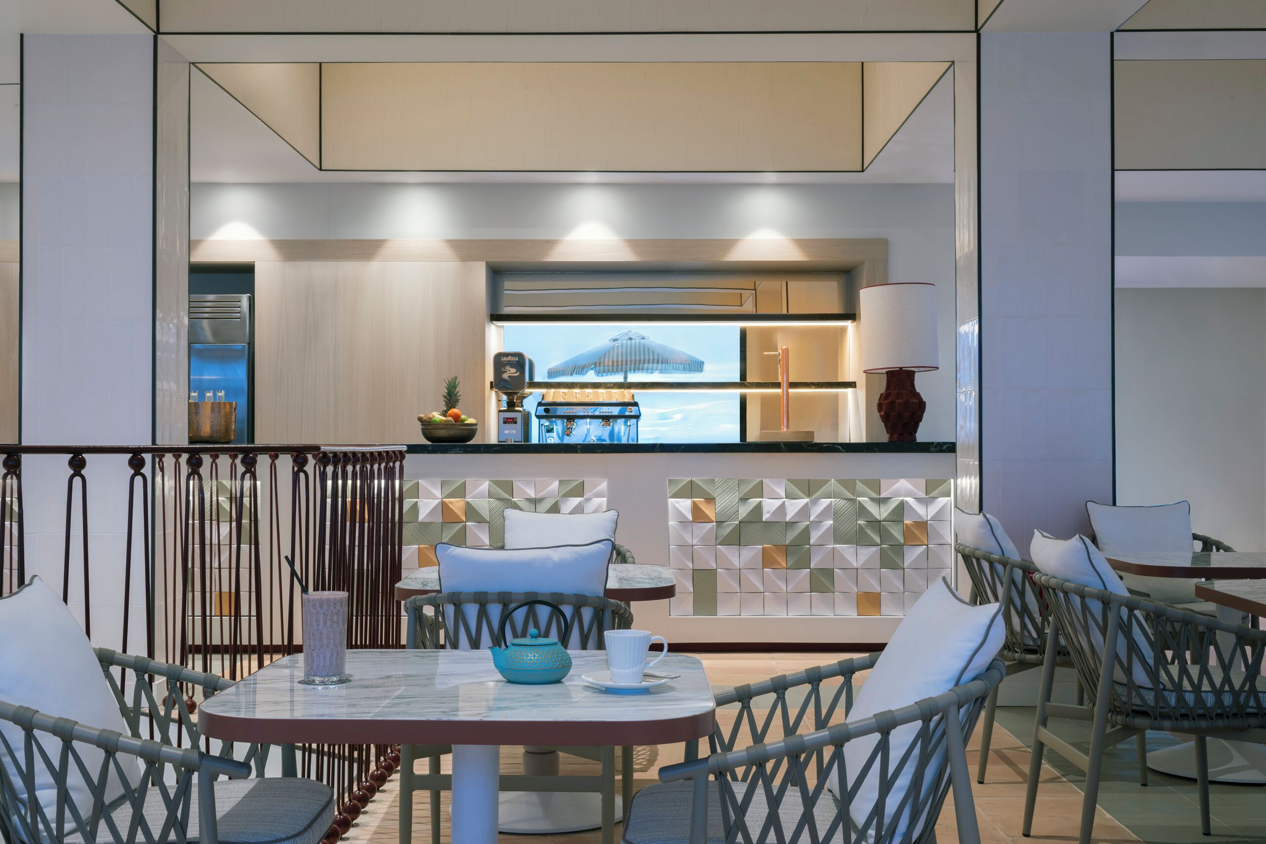 Un espace repas extérieur moderne, avec vue sur la cuisine et la piscine.