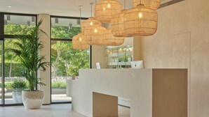 Una recepción con un diseño moderno, ventanas amplias y una planta en maceta.