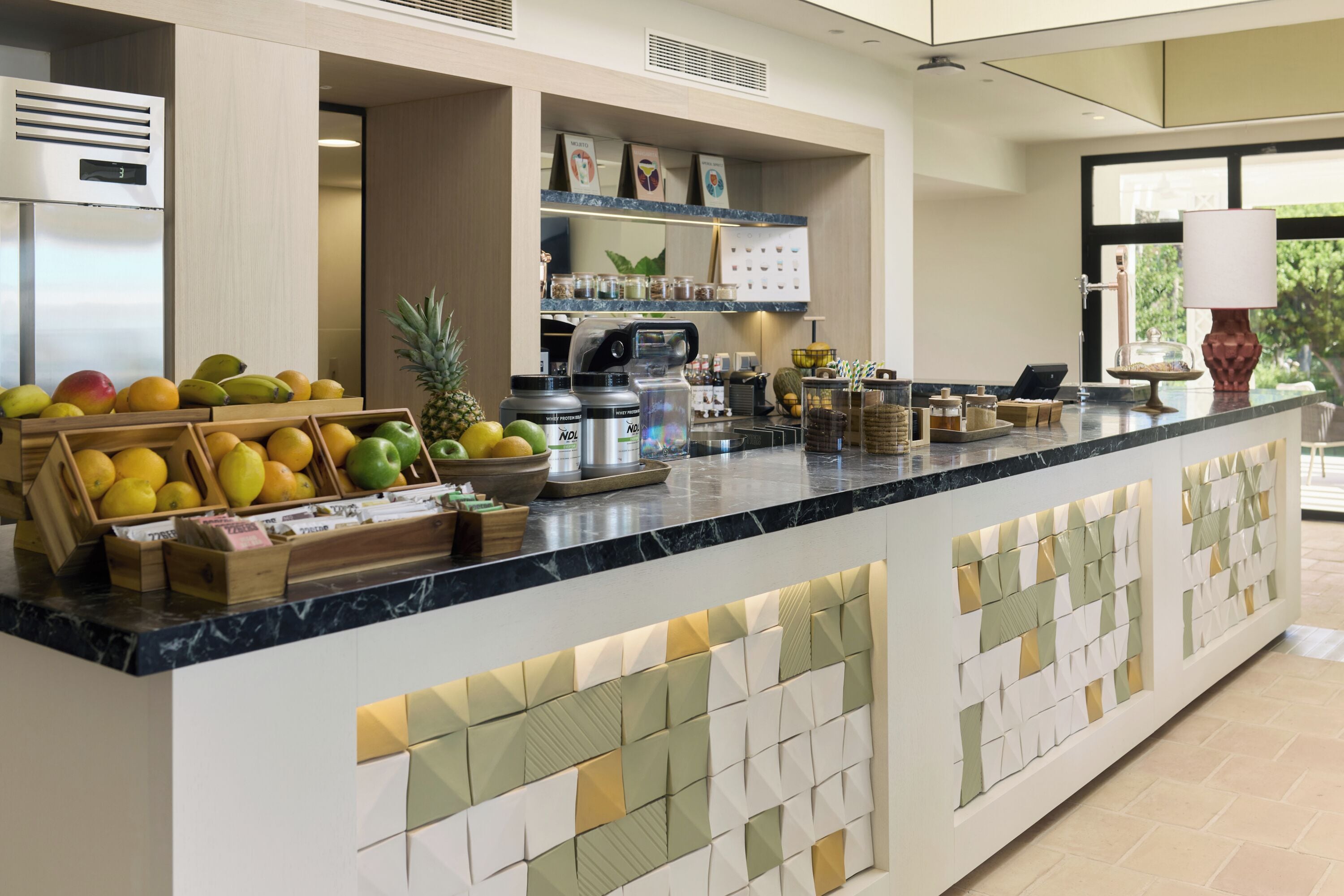 A kitchen counter with fruits, a coffee machine, and various kitchen appliances.