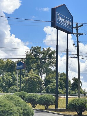 A Travelodge sign in Wyndham, with a clear sky and lush greenery in the background. - Travelodge by Wyndham Clarksville (Clarksville)