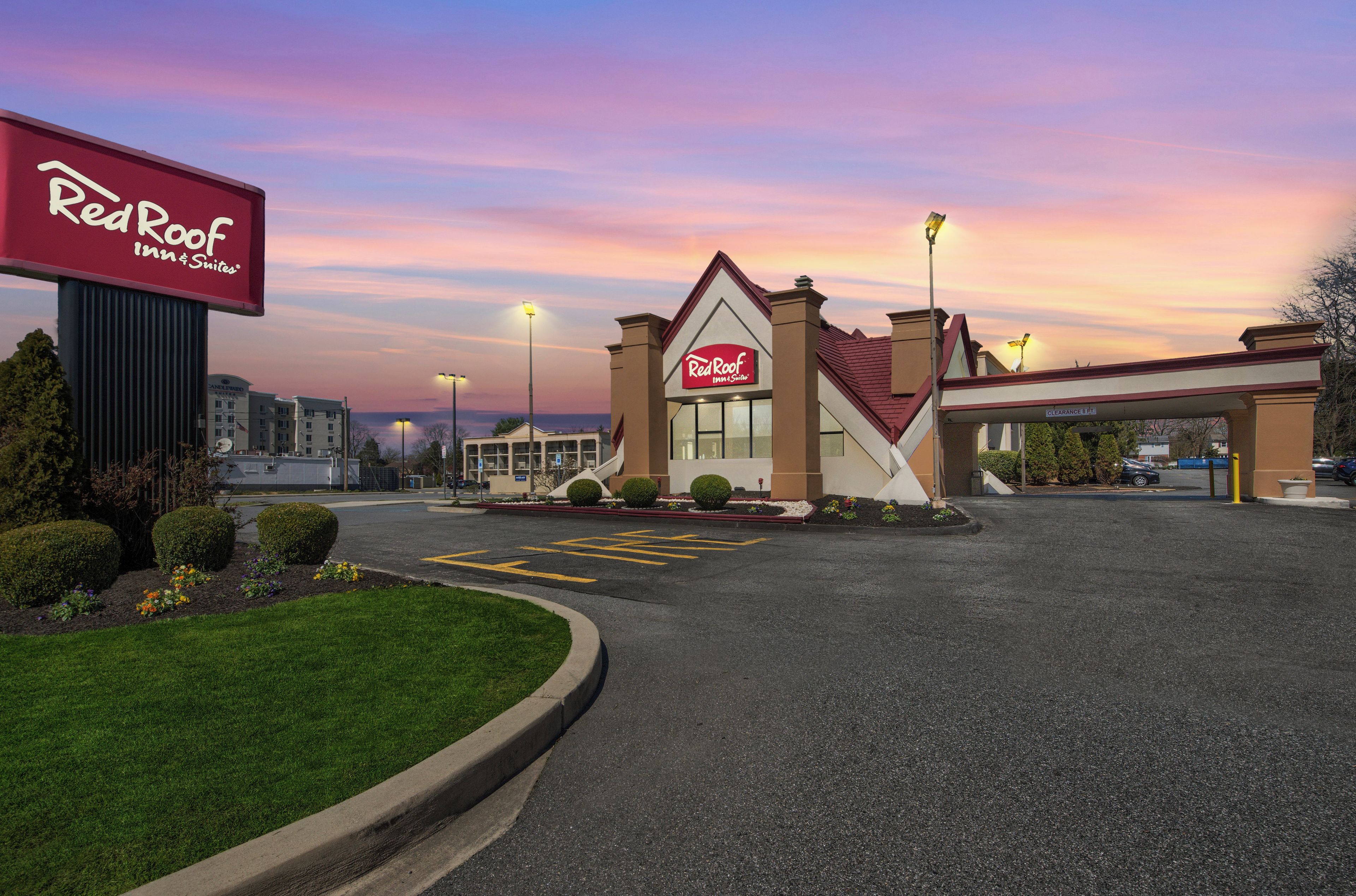 Un hôtel Red Roof Inn & Suites avec un ciel dégagé et un parking.