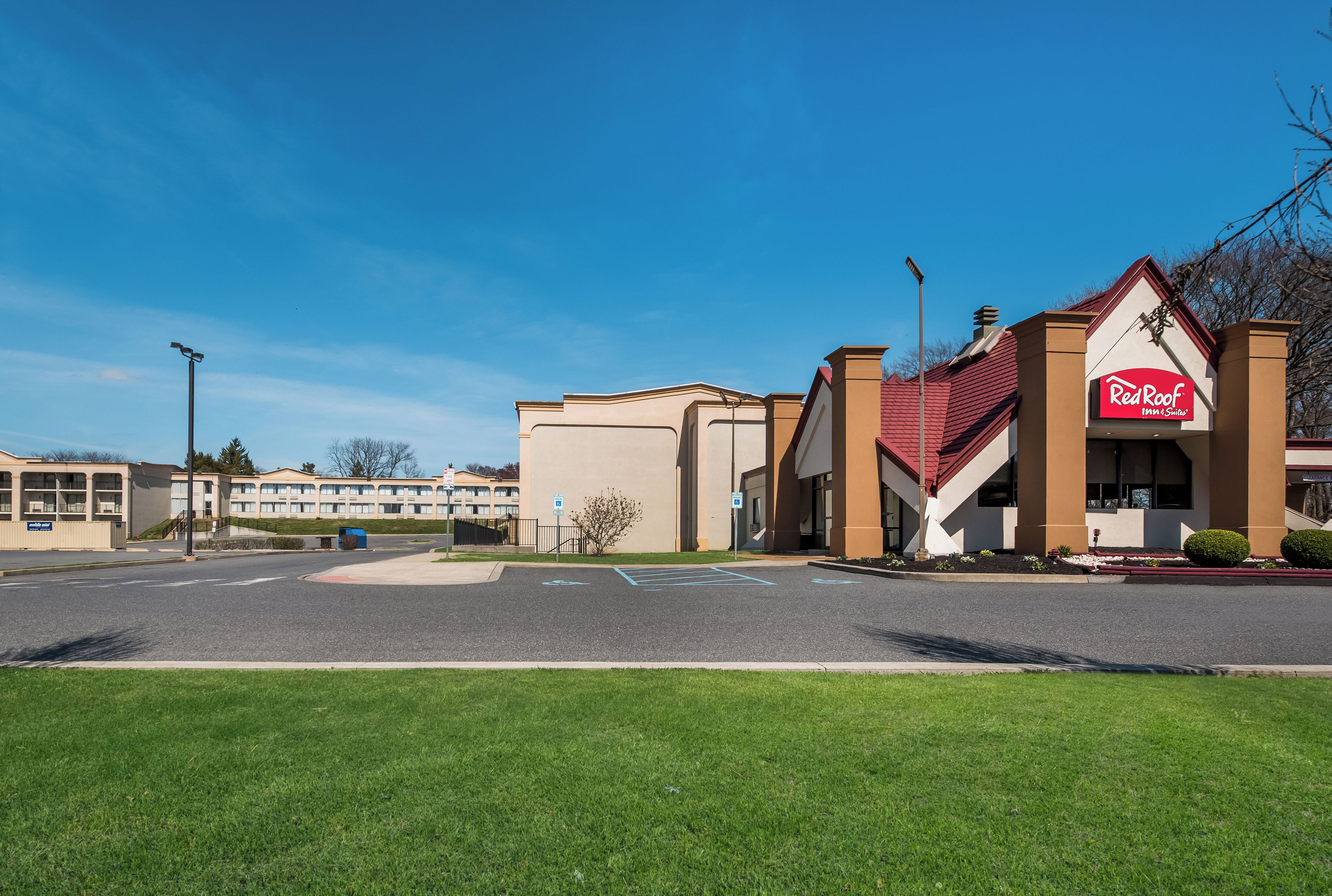 Un hotel Red Roof Inn & Suites con un estacionamiento al frente.