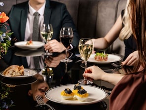 A formal dining setting with a table set for four, featuring a variety of dishes and wine glasses. - Sofitel Brisbane Central (Brisbane)