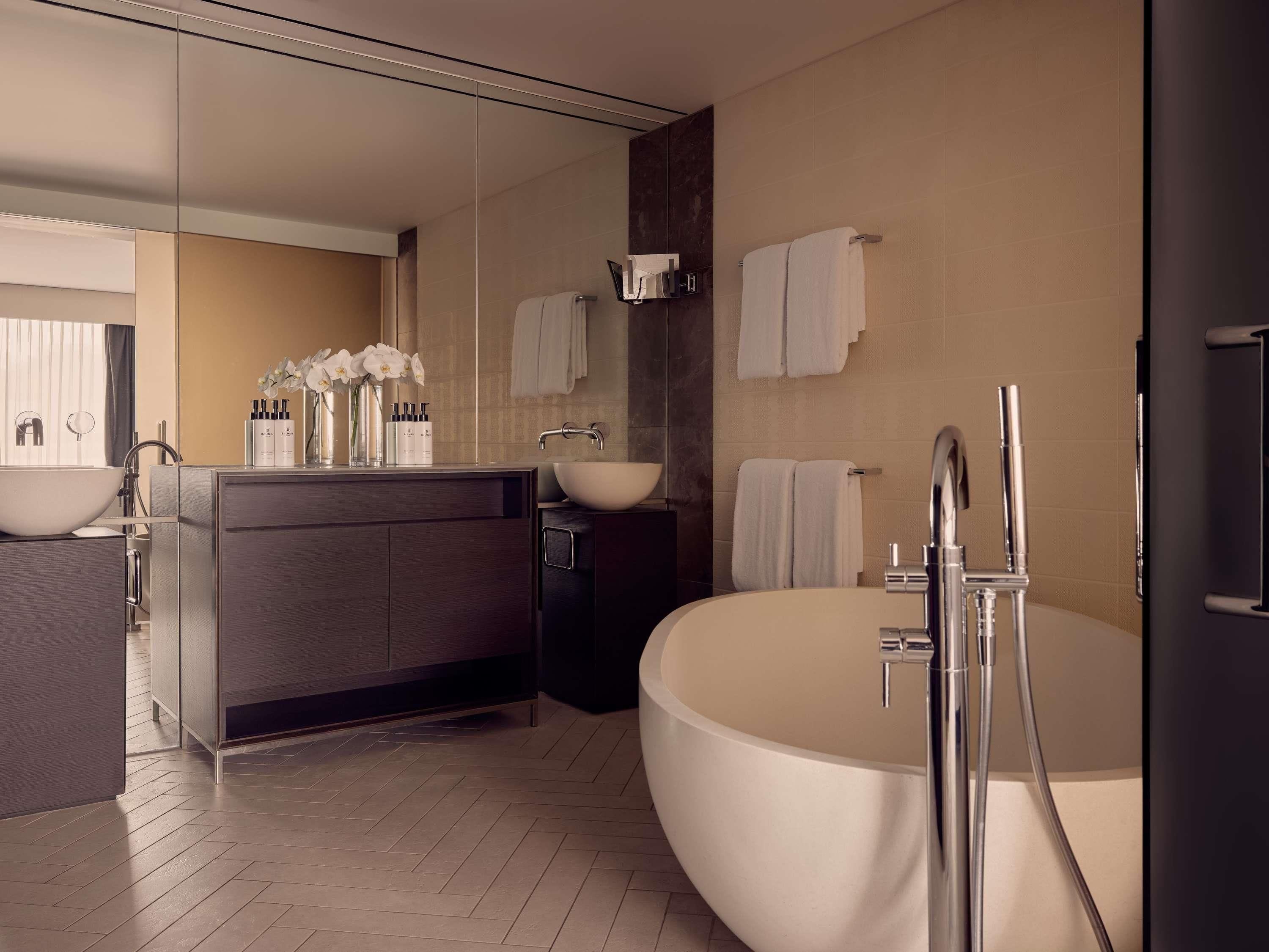 A modern bathroom with a freestanding bathtub, a vanity with a large mirror, and a separate sink area.