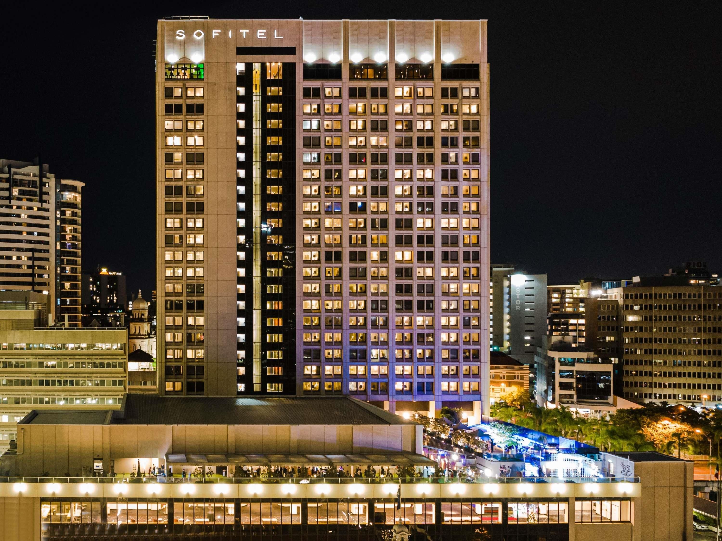 Un grand hôtel à plusieurs étages, avec une enseigne bien visible au sommet et une façade bien éclairée.