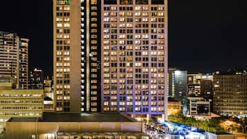 A high-rise hotel with multiple floors, a prominent sign at the top, and a well-lit facade.