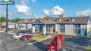 A Days Inn with a parking lot, a red truck, and a clear blue sky. - Days Inn by Wyndham Pauls Valley (Pauls Valley)