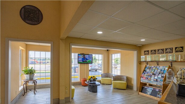 A lobby with a reception desk, seating area, and a TV screen. - Days Inn by Wyndham Pauls Valley (Pauls Valley)