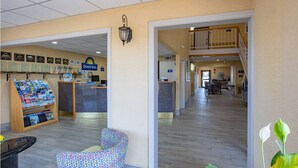 A reception area with a counter, a chair, and a display of brochures. - Days Inn by Wyndham Pauls Valley (Pauls Valley)