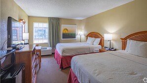 A hotel room with two beds, a desk with a computer, a TV, and a window with curtains. - Days Inn by Wyndham Pauls Valley (Pauls Valley)