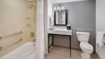 A modern bathroom with a bathtub, shower, toilet, and vanity.